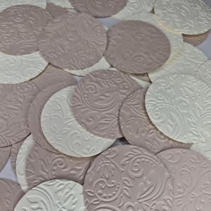 Peut inclure: Un ensemble de découpes de papier rondes et gaufrées, de couleurs blanche et mauve. Chaque découpe présente un motif floral et tourbillonnant détaillé. Les découpes sont dispersées, créant un effet texturé et superposé, adapté aux travaux manuels ou aux décorations.
