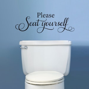 May include: White toilet with a black vinyl decal that reads "Please Seat Yourself" on a light blue wall.