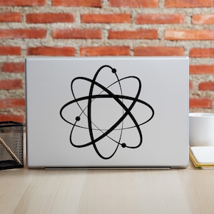 May include: A black and white atom symbol sticker on a silver laptop.