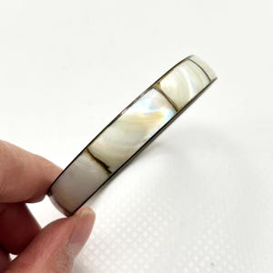 May include: A white ceramic mug with a black handle and the text "But First, Coffee" in a black, handwritten-style font. The mug is on a white surface.