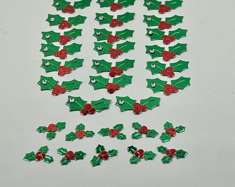 May include: A collection of green and red holly leaf stickers with silver glitter accents. The stickers are perfect for adding a festive touch to crafts, cards, and gifts.