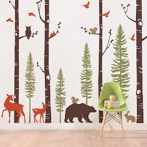 May include: A brown bear walks through a forest scene with a squirrel on its back. The forest scene includes brown birch trees, green pine trees, and red birds. There are also two deer in the scene.