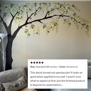 May include: A wall decal featuring a stylized tree with a dark brown trunk and branches. The leaves are a mix of light and dark green. The decal is approximately 96 inches in size. The text in the image says, "This decal turned out spectacular!"