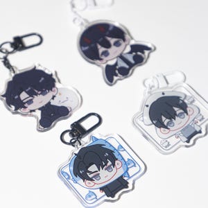 Pode incluir: Quatro chaveiros de acrílico em estilo anime com fechos de metal preto. Cada chaveiro apresenta um personagem de desenho animado diferente com cabelo preto e várias roupas. Os chaveiros são transparentes em um fundo branco.