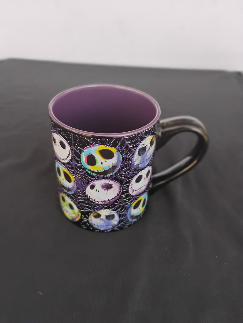 May include: A white ceramic mug with a black handle and the text "But First, Coffee" in a handwritten style. The mug is on a white surface. The mug is likely used for hot drinks.