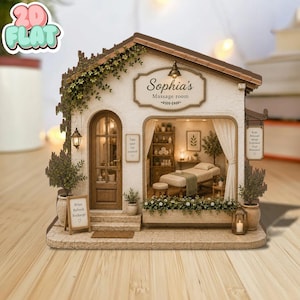 Op de afbeelding: Een miniatuurmodel van een massageruimte genaamd Sophia's Massage room. Het bouwwerk heeft een bruin dak, witte muren met klimplanten, een houten deur, een groot raam met zicht op een massagetafel en bordjes met tekst, waaronder Relax, Refresh, Recharge en Body, Relaxed, Mind, Renewed, Soul, Restored.