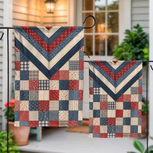 May include: Two rectangular garden flags featuring a patchwork design of red, navy blue, and cream squares. The patterns include small floral prints, gingham checks, and stripes. A chevron pattern in the same colours sits at the top of each flag.