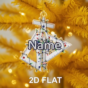 May include: A personalized Christmas ornament with the word "Name" in blue and white, surrounded by a silver compass and ruler design. The ornament is decorated with colorful string lights and the text "2D FLAT" at the bottom.