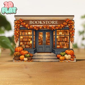 Puede incluir: Una librería en miniatura con temática otoñal. La fachada presenta un toldo marrón con la palabra "BOOKSTORE". Las ventanas y la puerta son azules, con calabazas y hojas de otoño. Se ven estanterías en el interior.