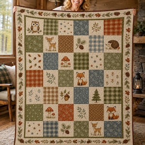 Puede incluir: Una colcha de patchwork con temática de bosque que presenta cuadrados con ilustraciones de búhos, ciervos, zorros, erizos, setas, piñas y abetos, intercalados con patrones de cuadros, vichy y estrellas en tonos tierra.