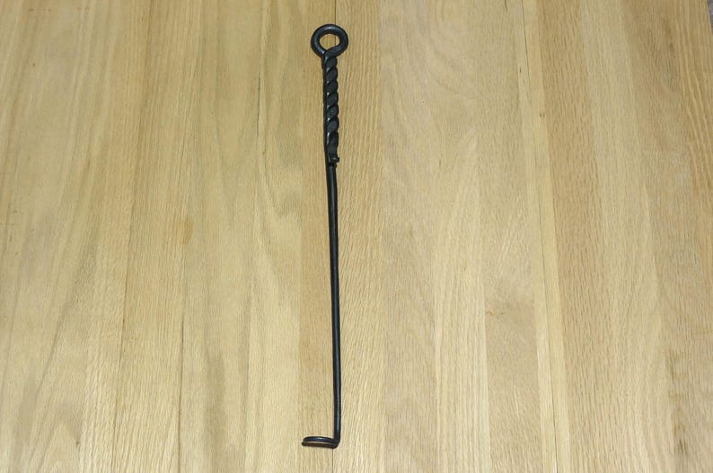 May include: A black metal fireplace poker with a twisted handle and a hook at the end.