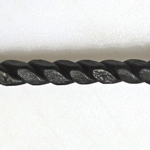 May include: A black metal fireplace poker with a twisted handle.