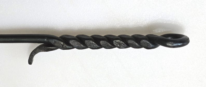May include: A black metal fireplace poker with a twisted handle.