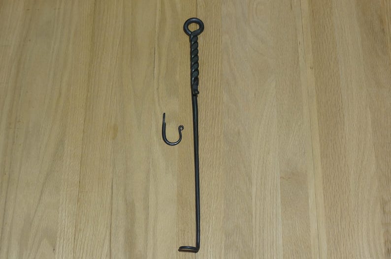 May include: A black metal fireplace tool with a twisted handle and a hook on the end. The tool is about 30 inches long.