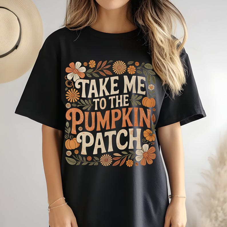 May include: Black t-shirt with the text "TAKE ME TO THE PUMPKIN PATCH" in orange and white, surrounded by floral and pumpkin graphics. The shirt is a casual, oversized fit.