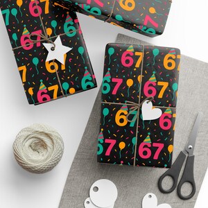 May include: Gifts wrapped in black paper printed with the number 67 in orange, pink, and teal, plus party hats and confetti. The presents are tied with twine and have white tags. A ball of twine, scissors, and blank tags are also present.