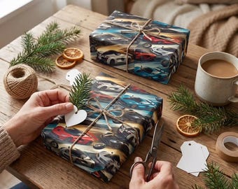 May include: Two wrapped gifts with car-themed wrapping paper are tied with twine on a wooden table. A person is adding a sprig of greenery and a heart-shaped tag to one of the gifts. A cup of coffee, dried orange slices, and a ball of twine are also on the table.