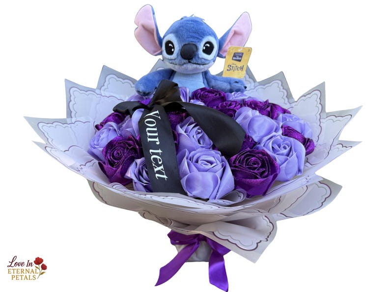 Op de afbeelding: Een boeket van paarse en lavendelkleurige rozen van lint, bekroond met een Stitch-knuffel. Het boeket is verpakt in decoratief papier en vastgebonden met een paars lint. Een zwart lint met de tekst "Your text" is ook inbegrepen.