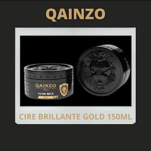 Puede incluir: Un tarro negro de cera para el cabello con un logotipo de león dorado y el texto "QAINZO Hair Wax Gold" en la etiqueta. El tarro está sobre una superficie negra con el texto "CIRE BRILLANTE GOLD 150ML" debajo.