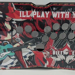 Puede incluir: Un panel de controlador arcade rectangular con un gráfico de un personaje con sombrero rojo y guitarra turquesa. El texto dice "I'LL PLAY WITH YOU." y "GUILTY GEAR". El panel tiene múltiples recortes circulares para botones y un logo adhesivo.