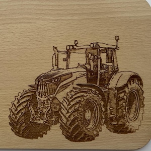 Könnte beinhalten: Ein Schneidebrett aus Holz mit einem lasergravierten Bild eines Traktors. Der Traktor ist braun und schwarz und hat große Räder.