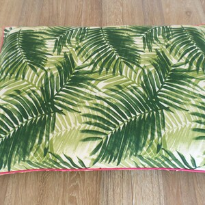 Op de afbeelding: Rechthoekig kussen met een groen palmbladpatroon op een witte achtergrond. Het heeft een felroze rand. Het kussen is waarschijnlijk voor de woondecoratie, afmetingen van ongeveer 40 cm x 60 cm.