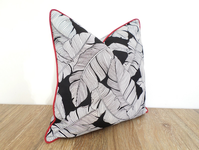 black outdoor pillow with tropical palm leaf print
