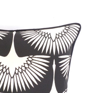 May include: Decorative pillow with a black and white crane design. The pillow features a repeating pattern of stylized cranes with outstretched wings against a black background. The pillow has a black border.