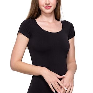 Può includere: Una maglietta nera a scollo rotondo e maniche corte, con un taglio aderente.