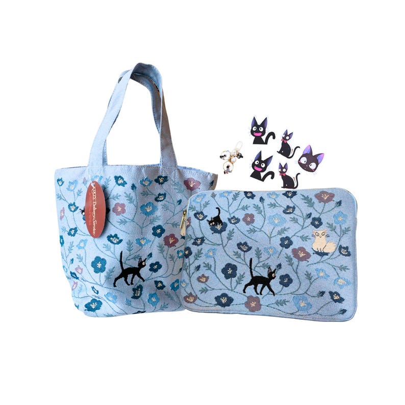Pu&ograve; includere: Una borsa tote azzurra e una pochette con cerniera abbinata, entrambe decorate con un motivo floreale e sagome di gatti neri. La borsa tote ha un manico e un'etichetta. &Egrave; presente anche una collezione di accessori a tema gatto.