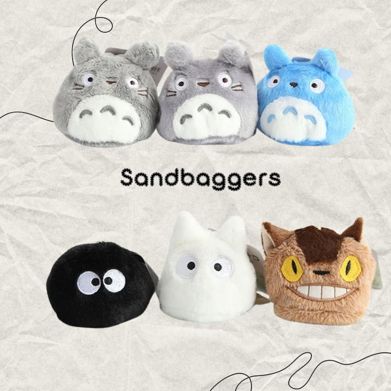 May include: Six plush character toys in various colors, including gray, blue, white, brown, and black. The toys have cartoon-like features and are arranged in two rows. The word "Sandbaggers" is printed in black text.