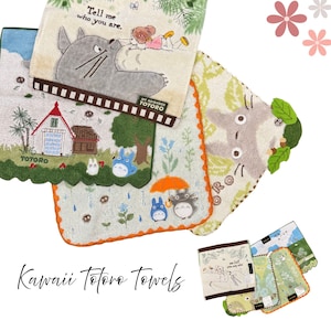 May include: A collection of colorful, decorative towels featuring illustrations of characters from the animated film "My Neighbor Totoro." The towels have various designs, including Totoro, houses, and nature scenes. The text "Tell me who you are" is visible.