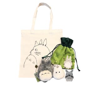 May include: A collection of Studio Ghibli merchandise featuring Totoro. Includes a cream tote bag with a black illustration, a green drawstring bag, and plush toys of Totoro and other characters.