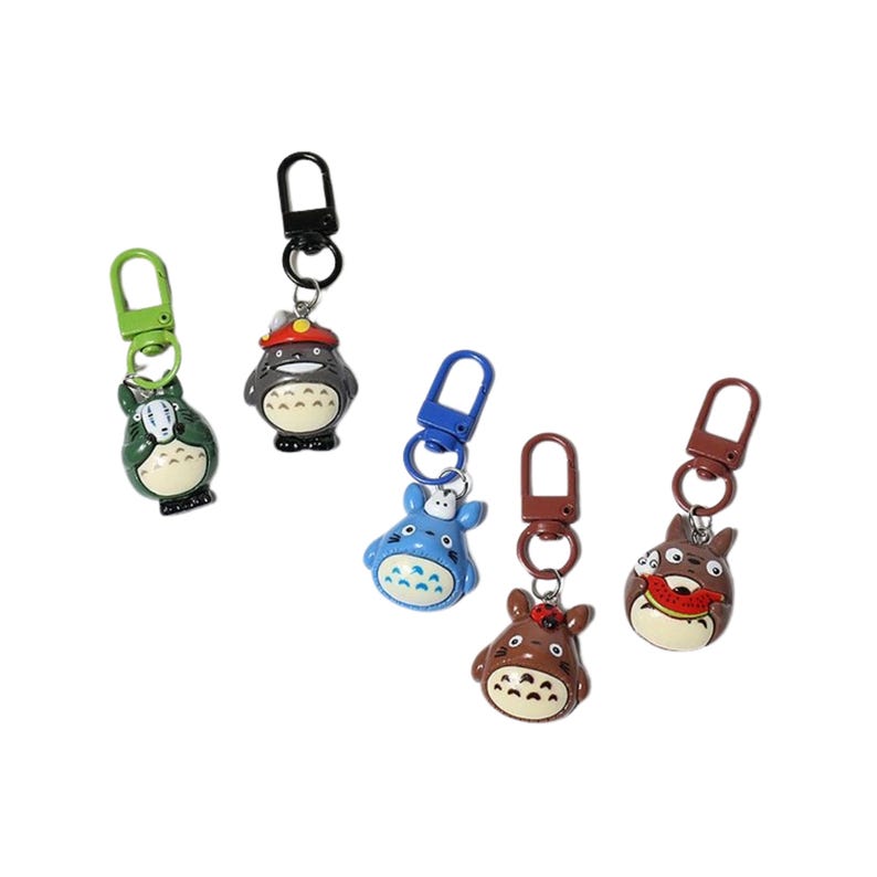 May include: Five cartoon character keyrings with lobster claw clasps. The keyrings feature characters in green, grey, blue, brown, and dark brown with various facial expressions and accessories. The clasps are in matching colours.