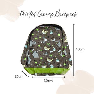 May include: A brown canvas backpack with a cat pattern, measuring 10cm deep, 30cm wide, and 40cm tall. The backpack has a green bottom and the text "Printed Canvas Backpack" at the top.