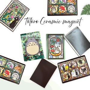 Może przedstawiać: Kolekcja ceramicznych magnesów z różnymi wzorami. Magnesy prezentują ilustracje postaci Totoro i innych dzieł sztuki w stylu anime. Tekst "Totoro Ceramic magnet" jest widoczny na zdjęciu.