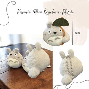 Puede incluir: Peluche llavero Kawaii Totoro gris claro, con un paraguas verde oscuro y una cadena plateada. El peluche mide aproximadamente 7 cm de alto. La imagen muestra varios peluches, algunos con llaveros.