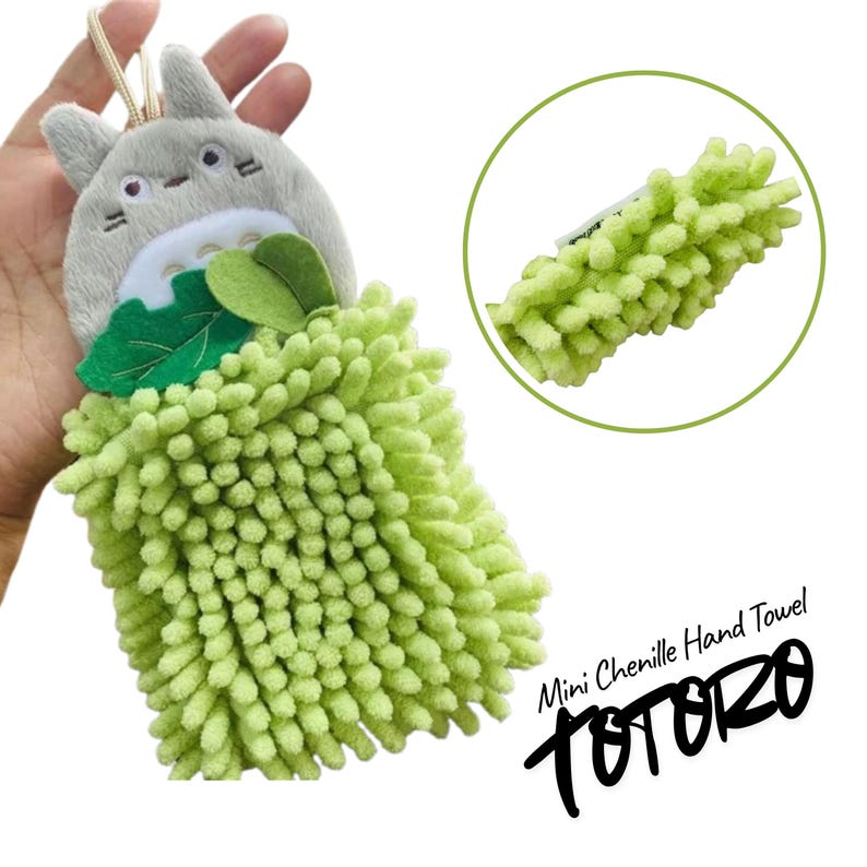 Puede incluir: Una mini toalla de mano de chenilla con un dise&ntilde;o de Totoro. La toalla tiene un cuerpo de chenilla verde claro y texturizado y una cabeza de personaje de Totoro gris con hojas verdes. El texto "Mini Chenille Hand Towel" y "Totoro" tambi&eacute;n son visibles.