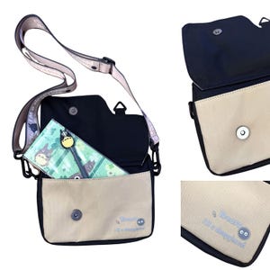 May include: A black and beige messenger bag with a flap closure. The bag features a shoulder strap with the text "I'M a sleepyhead". Inside the bag is a green pencil case with a cartoon character design. The bag has a magnetic clasp.