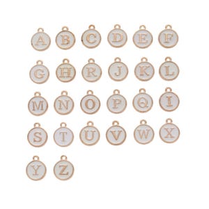 May include: A collection of gold-colored alphabet charms, each featuring a white enamel background. The letters A through Z are displayed in a serif font, perfect for personalized jewelry or craft projects.