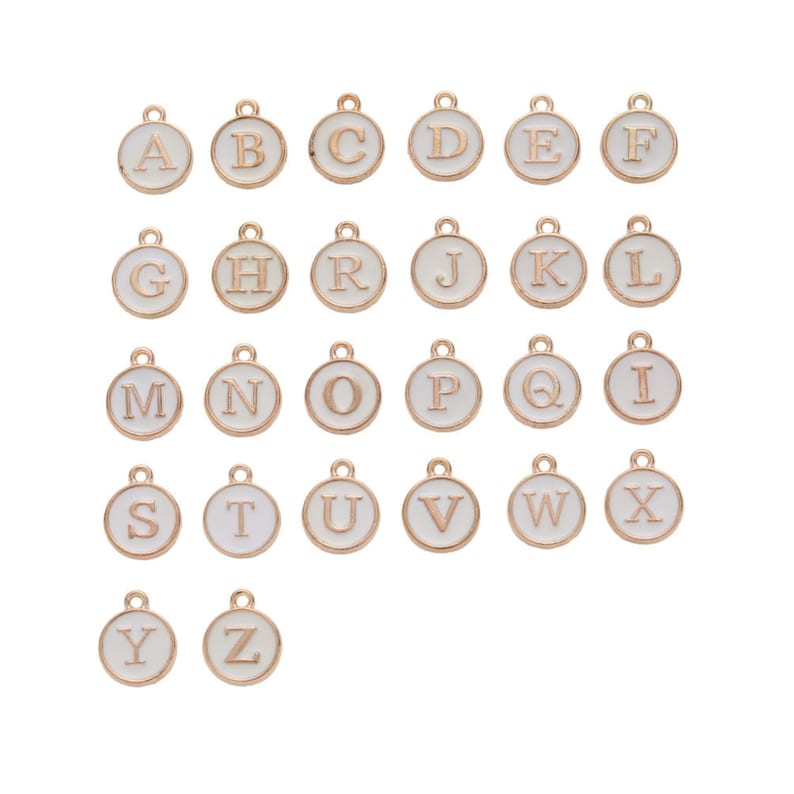 May include: A collection of gold-colored alphabet charms, each featuring a white enamel background. The letters A through Z are displayed in a serif font, perfect for personalized jewelry or craft projects.