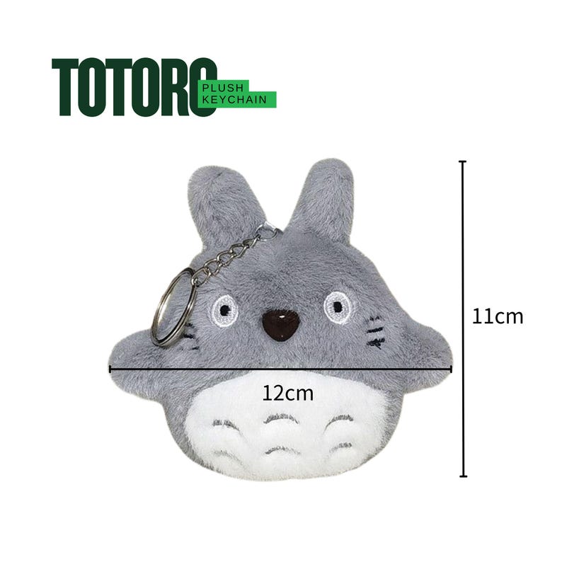 May include: A plush Totoro keychain, approximately 4.7 inches wide and 4.3 inches tall. The gray plush figure has a white belly, black eyes, and a brown nose. The keychain includes a metal ring and chain, with the word "TOTORO" above it.