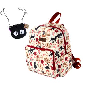 May include: A cream-colored backpack featuring a repeating pattern of black cats, birdcages, red mugs, and pink flowers, with red zippers and straps. A small black drawstring pouch with a cat face design is included as a separate accessory.