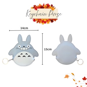 May include: A light blue keychain purse shaped like a cartoon character, with a smiling face and a white belly. The purse is 5.5 inches wide and 5.9 inches tall. The text "Keychain Purse" is above the purse.