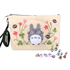 May include: Cream corduroy pouch with an embroidered Totoro character, pink flowers, and green vines. It has a black zip, a black wrist strap, and character keychains. The tag reads "MY NEIGHBOR TOTORO".