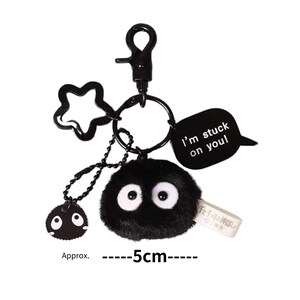 May include: Black plush keychain featuring a character with large eyes and a speech bubble that reads "I'm stuck on you!" The keychain is approximately 5 inches long.