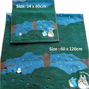 May include: Two green and blue bath towels with a forest design and Totoro characters. The larger towel measures 23.6 x 47.2 inches, and the smaller towel is 13.4 x 31.5 inches. The towels have a brown border and white text.