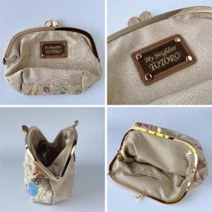 May include: Beige coin purse with a metal clasp and a floral pattern on the bottom. The purse has a brown leather tag that reads "My Neighbor TOTORO". The interior is a light beige color.