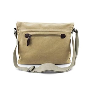 May include: A tan canvas messenger bag with a flap closure and a zippered pocket on the back. The bag has a gray adjustable shoulder strap and a brown zipper pull.