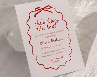 May include: White invitation card with red text and a decorative border. The text reads "she's tying the knot" and invites guests to a bridal shower honoring Olivia Watson. Details include the date, time, and location.